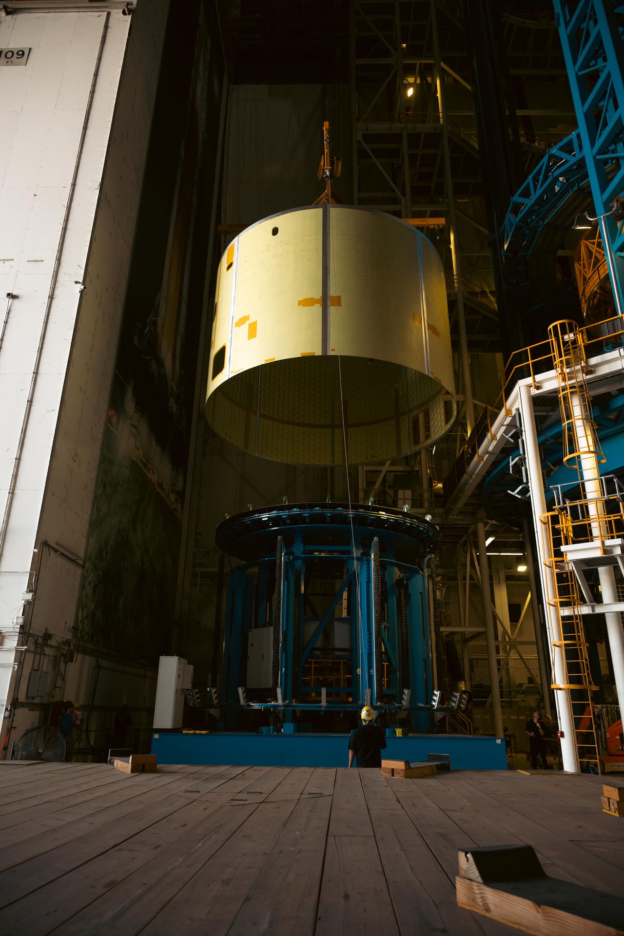 Teams at Michoud Assembly Facility in New Orleans load the engine section barrel into the vertical assembly center on Aug. 5, 2026. The engine section will be used on the SLS (Space Launch System) rocket’s core stage for the agency’s Artemis V mission. On the vertical assembly center tooling, teams will mate the flight hardware to a ring, which will serve as an attachment point for the liquid hydrogen tank later in the production process.    The engine section is one of five major elements that make up the 212-foot-tall SLS rocket stage; and houses various avionic systems, the engine thrust structure, and four RS-25 engines. The core stage produces more than two million pounds of thrust to help launch NASA’s Orion spacecraft, astronauts, and supplies beyond Earth’s orbit and to the lunar surface for Artemis.